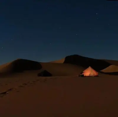 a tent in the middle of a desert at night at Sahara lumière in Mhamid El Ghizlane