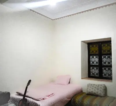 a bedroom with a pink bed and a window at Hostel Ighounane in Ouarzazate