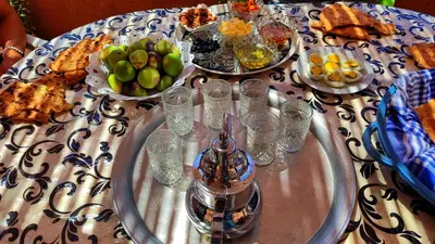 a table with plates of food and glasses on it at Hostel Ighounane in Ouarzazate