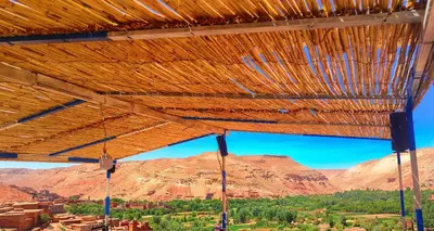 a wooden roof with a view of a mountain at Hostel Ighounane in Ouarzazate