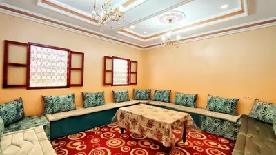 a room with a table and chairs and a ceiling at Hostel Ighounane in Ouarzazate
