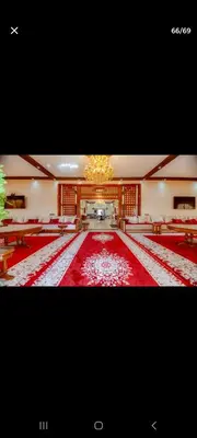a large room with a red carpet and a chandelier at Zaouiet ben sassi in Marrakech