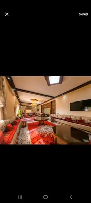 a large living room with a large red carpet at Zaouiet ben sassi in Marrakech