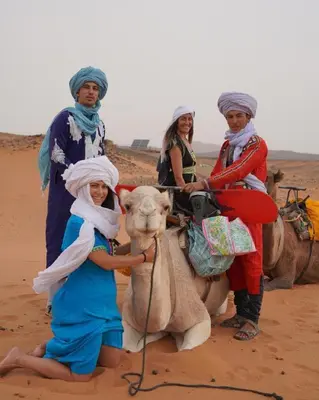 a group of people riding on the back of a camel at Chic Boheme Camp in Merzouga