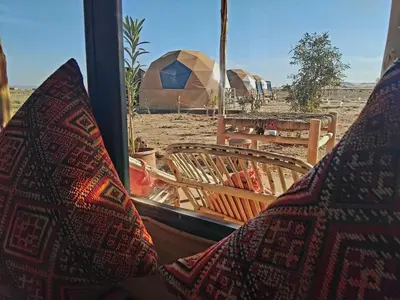 a view of a desert from a window with tents at Chic Boheme Camp in Merzouga