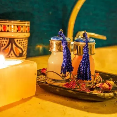 a candle and two jars of honey on a table at Chic Boheme Camp in Merzouga