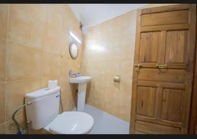 a bathroom with a toilet and a sink and a door at Riad Maison Haddaji Fez in Fès