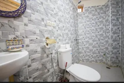a bathroom with a white toilet and a sink at Riad Maison Haddaji Fez in Fès