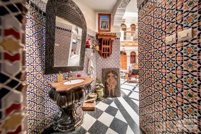 a bathroom with a sink and a mosaic wall at Riad Maison Haddaji Fez in Fès