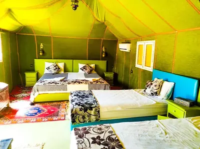 a room with two beds in a tent at Oasis Luxury Camp in Merzouga