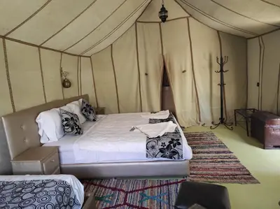 a bedroom with a bed in a tent at Oasis Luxury Camp in Merzouga