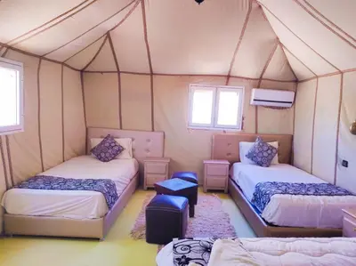 a room with two beds in a tent at Oasis Luxury Camp in Merzouga