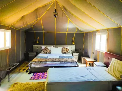 a bedroom with two beds in a tent at Oasis Luxury Camp in Merzouga