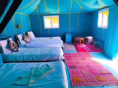 a room with three beds in a tent at Oasis Luxury Camp in Merzouga