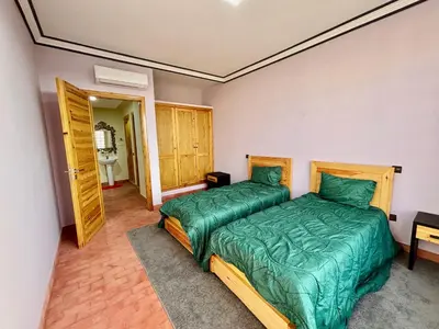 a bedroom with two beds and a bathroom at Cabanne ourika in Marrakech
