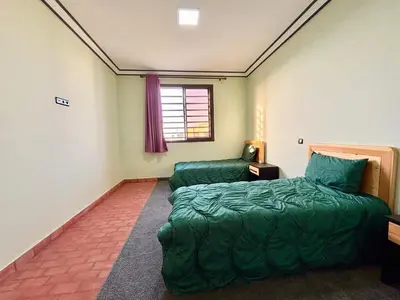 a bedroom with a bed and a chair in it at Cabanne ourika in Marrakech