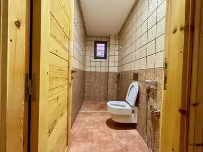 a bathroom with a toilet and a window and a door at Cabanne ourika in Marrakech
