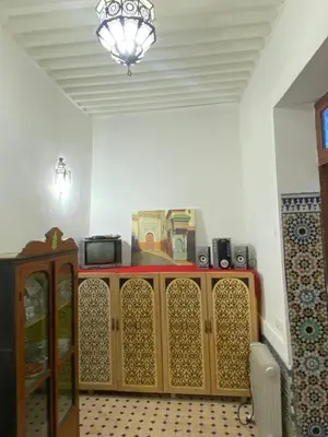 a room with a wooden cabinet with a chandelier at Dar ZaZ in Fès