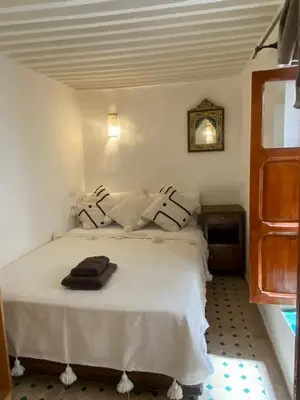 a bedroom with a bed with white sheets and pillows at Dar ZaZ in Fès