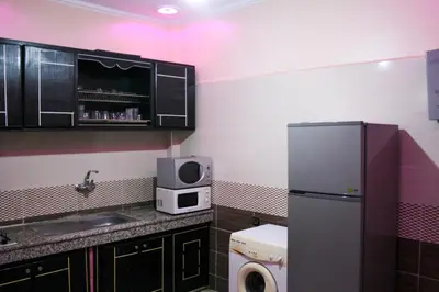 a small kitchen with a refrigerator and a microwave at city fes in Fès