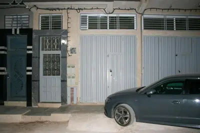 a blue car parked in front of a garage at city fes in Fès