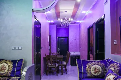 a living room with purple walls and a table and chairs at city fes in Fès