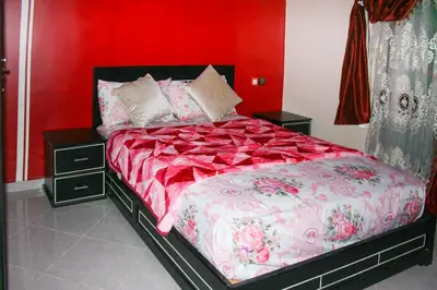 a bedroom with a bed with a red wall at city fes in Fès