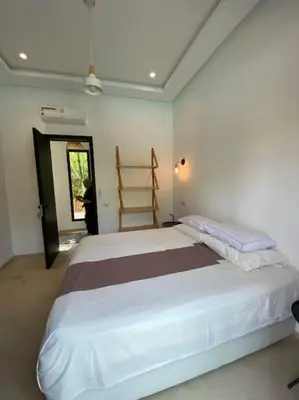 a bedroom with a large white bed in a room at Villa P5 avec piscine chauffée in Marrakech