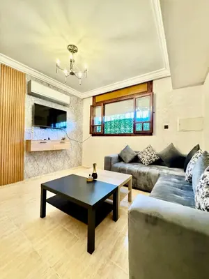a living room with a couch and a table at Atlas appartement in Fès