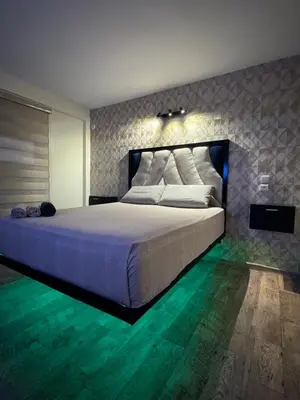 a bedroom with a large white bed with green floors at Atlas appartement in Fès