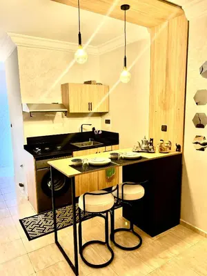 a kitchen with a island with two bar stools at Atlas appartement in Fès
