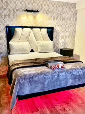 a bedroom with a large bed with a blue bed frame at Atlas appartement in Fès