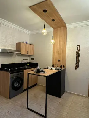a kitchen with a table and a stove and a sink at Atlas appartement in Fès
