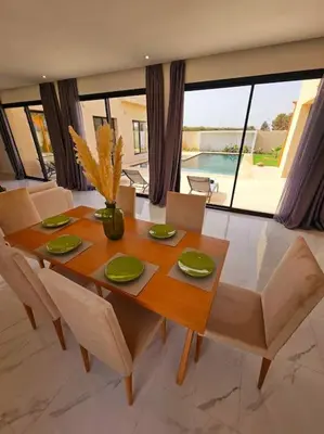 a dining room table and chairs with a table and a view at Villa Piscine Sans Vis à Vis in Marrakech