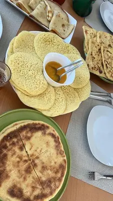a table topped with plates of food with pies and bread at Villa Piscine Sans Vis à Vis in Marrakech