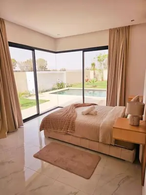 a bedroom with a bed and a large window at Villa Piscine Sans Vis à Vis in Marrakech