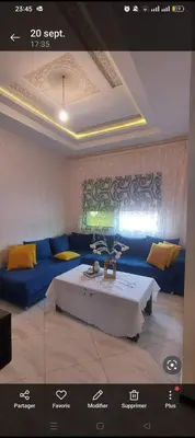 a living room with a blue couch and a table at Mamoune benz in Fès