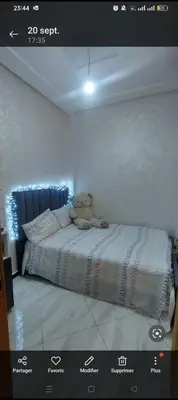 a teddy bear sitting on a bed in a bedroom at Mamoune benz in Fès