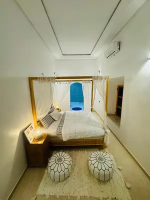 a bedroom with a bed with a window and two circular pillows at Riad Kasbah Ben Hamo in Nkob