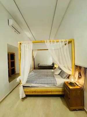 a bedroom with a canopy bed in a room at Riad Kasbah Ben Hamo in Nkob