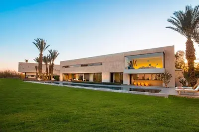 a large house with a lawn in front of it at Palais des jardins in Ouarzazate
