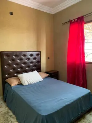 a bedroom with a blue bed with a red curtain at Séjour Authentique à Marrakech in Marrakech