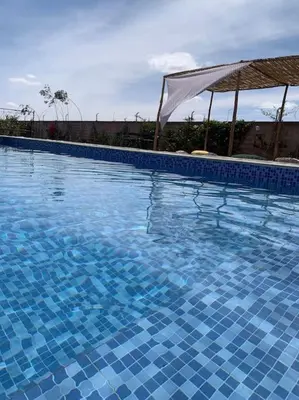 a large swimming pool with blue tiles on it at Séjour Authentique à Marrakech in Marrakech