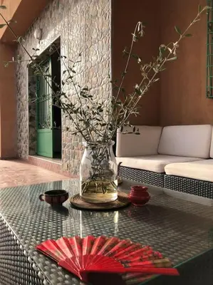a vase with flowers on a table in a living room at Séjour Authentique à Marrakech in Marrakech
