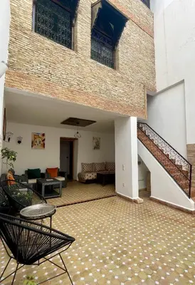 a building with a staircase and a living room at Riad Zahraa Al Ismailia in Meknès