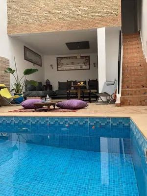 a large swimming pool in a living room at Riad Zahraa Al Ismailia in Meknès