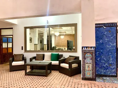 a living room with a couch and chairs and a table at Riad Zahraa Al Ismailia in Meknès