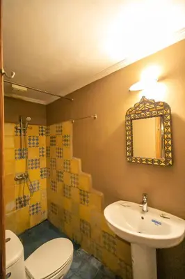 a bathroom with a sink and a toilet and a mirror at Riad Louna Fes & Spa in Fès