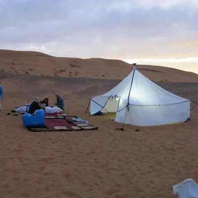 a group of people in the desert with a tent at Merzouga Desert Activities & Events in Merzouga