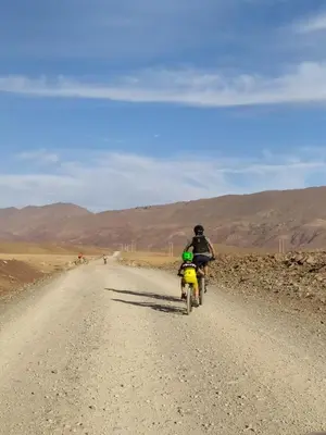 a person riding a bike on a dirt road at Merzouga Desert Activities & Events in Merzouga